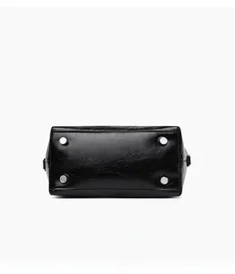 Detail view of the black textured leather bag base with four silver metal protective feet