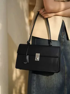 Minimalist black leather shoulder bag with silver buckle and adjustable strap