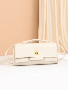 Minimalist creamy white shoulder bag with gold twist lock and structured top handle