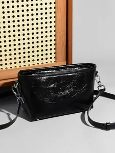 Chic black crossbody bag in genuine crinkled leather with shiny finish and silver hardware