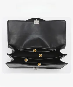 Detail view of the black leather shoulder bag showing layered interior storage compartments