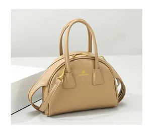 Detail van de beige zachte lederen handtas met gouden dubbele ritsen en schouderband