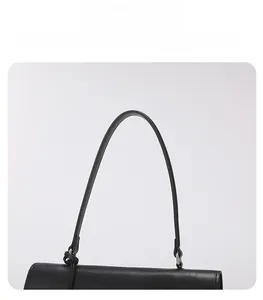 Detail view of the sleek black leather handbag handle with polished silver metal rings