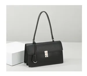 Close-up of black leather shoulder bag featuring silver metal buckle on a minimalist background