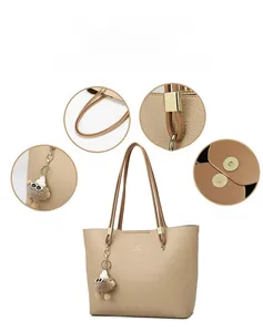 Detail view of khaki tote bag showing lychee grain, magnetic clasp, and fuzzy charm