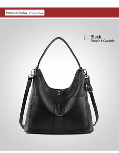 Detail of black pebbled leather tote bag showing front pockets and fine stitching
