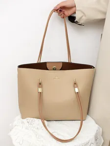 Detailed macro view of the beige lychee pattern leather tote bag with gold logo text
