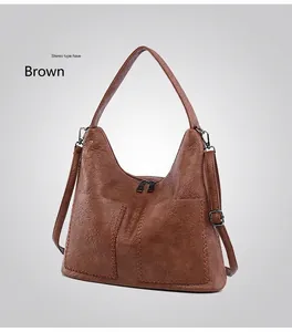 Detail view of brown pebbled leather tote with parallel stitching and double zippers