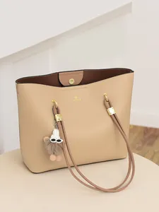 Elegant beige pebbled leather tote bag with gold logo and plush charm accessory