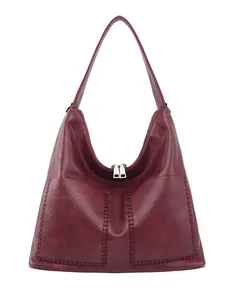 Detail view of burgundy leather tote featuring vertical stitching and metal zipper