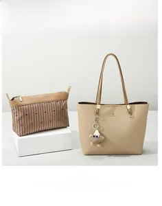 Beige pebble leather tote bag with striped zipper pouch and plush monster charm detail