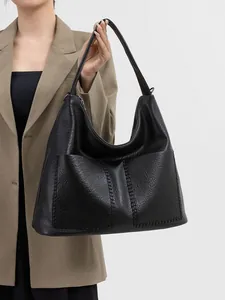 Detailed view of black pebbled leather tote bag with stylish contrast stitching craft