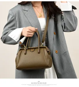 Olive green pebbled leather satchel with dual handles and brass hardware detail