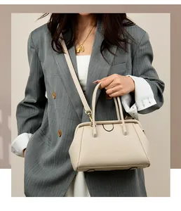 Detail of cream lychee texture leather tote bag with dual handles and long shoulder strap