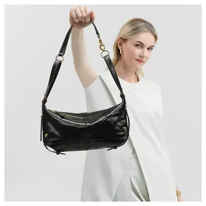 Detail of black quilted hobo bag featuring glossy faux leather and gold hardware