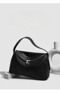 Detail of black lychee grain leather handbag with white stitching and silver T-shaped lock