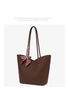 Close-up of deep brown lychee texture tote bag with a decorative plaid silk scarf handle