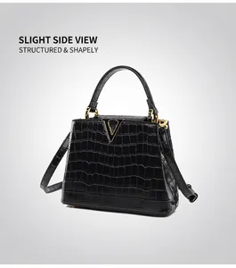 Détail du sac à main noir motif crocodile avec boucle métallique en V dorée