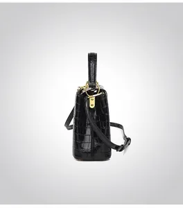 Vue latérale du sac seau en cuir noir motif crocodile avec détails métalliques dorés