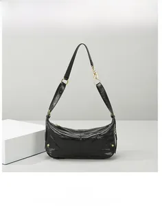 Macro shot of black quilted faux leather handbag with gold metal rings and rivets