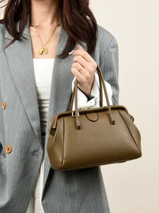 Olive green pebbled leather doctor bag with wide opening and metal zipper on model