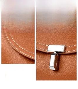 Detail of brown litchi pattern leather bag with white stitching and silver metal buckle