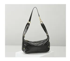 Close-up of black quilted hobo bag featuring glossy leather and bright gold hardware