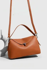 Detail of lychee pattern leather handbag with white stitching and T-shaped metal buckle
