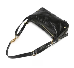 Detailed top view of black quilted leather shoulder bag with gold metal zipper and hardware