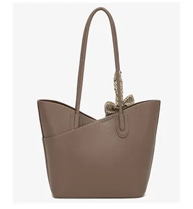 Detail of dark brown pebble leather tote bag with stylish houndstooth silk scarf handle