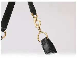 Close-up of black textured leather strap with premium gold D-ring hardware detailing