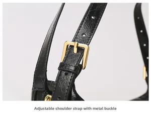 Close-up of adjustable black leather strap with gold metal buckle on shoulder bag