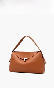 Close-up of brown pebbled leather handbag featuring white contrast stitching and silver T-buckle
