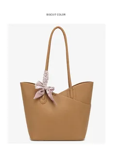 Detail of biscuit brown tote bag with leather texture and plaid silk scarf decoration