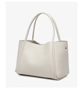 Macro-opname van gebroken witte leren shopper met metalen klinknagels aan de zijkant