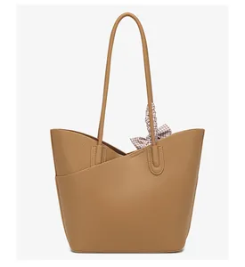 Detail of dark brown lychee leather tote with diagonal pocket and silk scarf accent