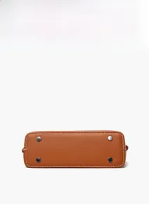 Detail of brown leather bag base with silver rivets and white contrast stitching