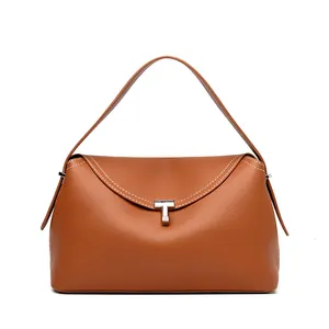 Detail of caramel brown lychee grain leather handbag with silver T-shaped metal lock