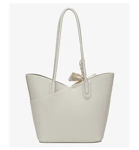 Close-up of cream leather tote bag with V-cut edge and elegant floral scarf detail