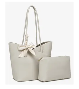 Detail of lychee pattern leather tote bag with a silk scarf bow and matching pouch