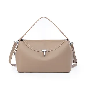 Detail of khaki leather texture and silver T-shaped metal buckle on the crossbody bag