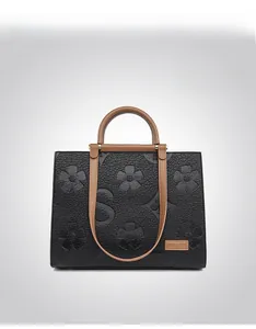Detail of embossed floral texture and contrast leather handle on large tote bag