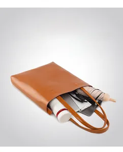 Spacious interior of brown leather tote bag holding iPad, umbrella, and daily essentials