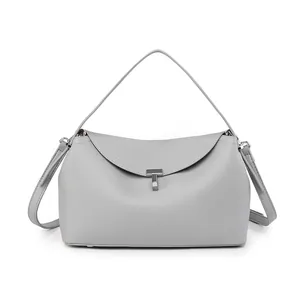 Detail of silver T-shaped lock on grey textured leather tote with premium stitching