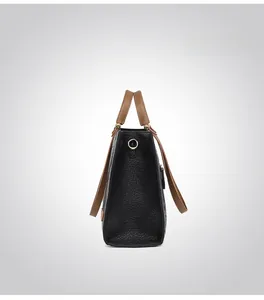 Side view showing the structured outline of the black lychee grain tote with brown straps