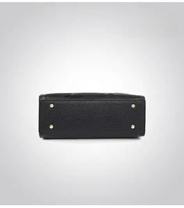 Detail of black embossed leather tote base with gold protective metal studs
