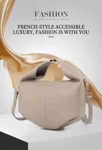 Detail of taupe leather crossbody bag with lychee texture and gold metal hardware