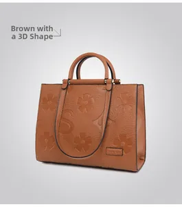 Detail of brown tote bag with 3D embossed floral patterns and lychee grain leather