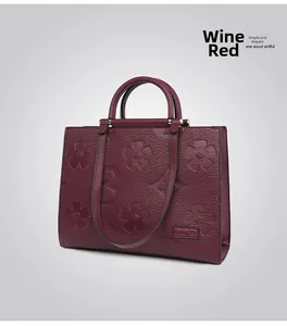 Detailed view of burgundy tote bag with textured leather and 3D floral embossing