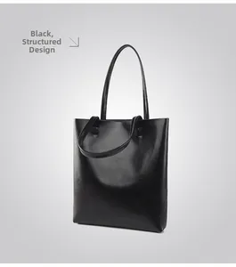 Close-up of black oil-wax leather tote bag showing glossy texture and dual handles